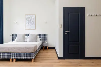 a bedroom with a bed and a black door at 1 bedroom apartment - Augustiańska 1 in Kraków