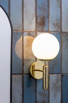 a lamp on a wall with a tiled wall at 1 bedroom apartment - Augustiańska 1 in Kraków