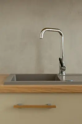 a kitchen sink with a faucet on a counter at Cozy studio - Augustiańska 1 street in Kraków