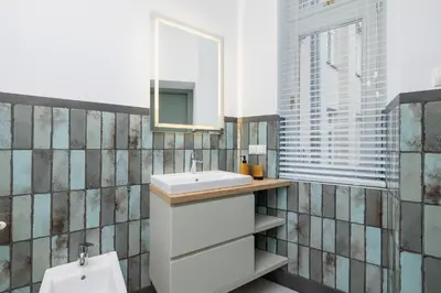 a bathroom with a sink and a mirror at Cozy studio - Augustiańska 1 street in Kraków