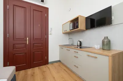 a kitchen with a red door and a counter top at Cozy studio - Augustiańska 1 street in Kraków