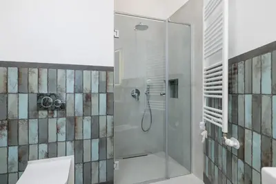 a shower with a glass door in a bathroom at Cozy studio - Augustiańska 1 street in Kraków