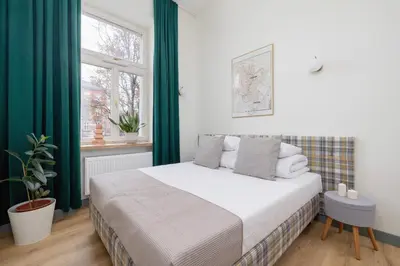a bedroom with a bed with green curtains and a window at Studio for 2 - Augustiańska 1 - Kazimierz in Kraków