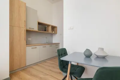a kitchen and dining room with a table and chairs at Studio for 2 - Augustiańska 1 - Kazimierz in Kraków