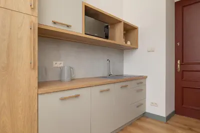 a small kitchen with white cabinets and a sink at Studio for 2 - Augustiańska 1 - Kazimierz in Kraków