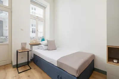 a small bedroom with a bed and a television at Cozy studio - Augustiańska 1 street in Kraków