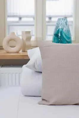 a pile of pillows sitting on top of a bed at Cozy studio - Augustiańska 1 street in Kraków