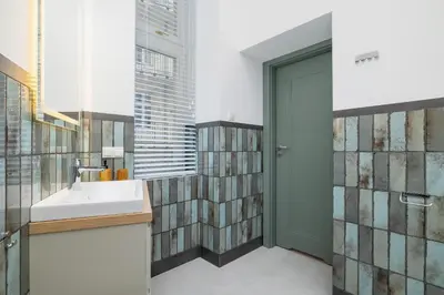 a bathroom with a sink and a glass door at Cozy studio - Augustiańska 1 street in Kraków