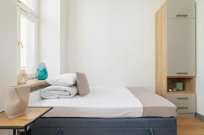 a bedroom with a bed and a table at Cozy studio - Augustiańska 1 street in Kraków