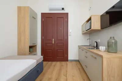 a small kitchen with a red door in a room at Cozy studio - Augustiańska 1 street in Kraków