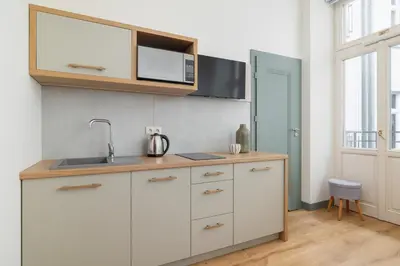 a kitchen with white cabinets and a sink at Cozy studio - Augustiańska 1 street in Kraków