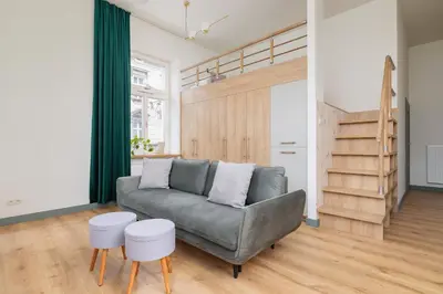 a living room with a couch and two stools at Cozy apartment - Augustiańska 1 street in Kraków