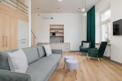 a living room with a gray couch and two chairs at Cozy apartment - Augustiańska 1 street in Kraków