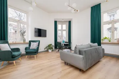 a living room with a couch chairs and a tv at Cozy apartment - Augustiańska 1 street in Kraków