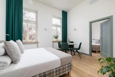 a bedroom with a bed with green curtains and a table at Apartment for 6 people - Augustiańska 1 in Kraków