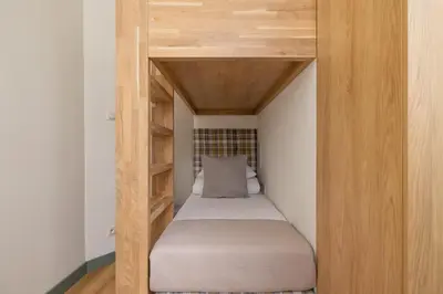a small bed in a small room with wooden shelves at Apartment for 6 people - Augustiańska 1 in Kraków