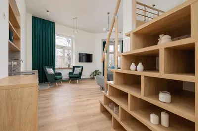 a room with wooden shelves and a living room at Apartment for 6 - Augustiańska 1 street in Kraków