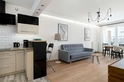 a kitchen and a living room with a couch at Klimatyzowany Apartament z Balkonem i Przestrzenią do Pracy Lokalizacja Blisko Wisły by Noclegi Renters in Kraków