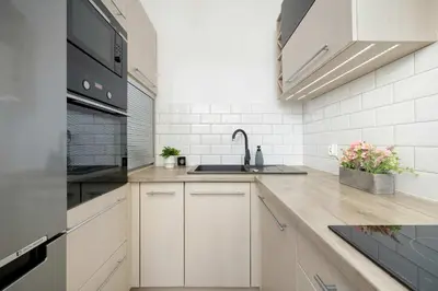 a kitchen with white cabinets and a sink at Klimatyzowany Apartament z Balkonem i Przestrzenią do Pracy Lokalizacja Blisko Wisły by Noclegi Renters in Kraków