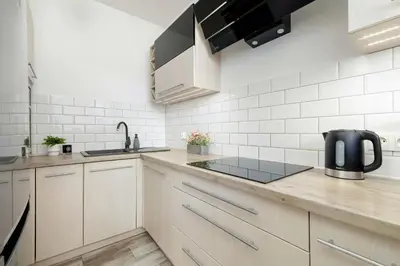 a kitchen with white cabinets and a sink at Klimatyzowany Apartament z Balkonem i Przestrzenią do Pracy Lokalizacja Blisko Wisły by Noclegi Renters in Kraków