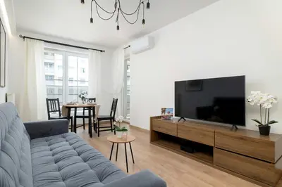 a living room with a couch and a flat screen tv at Klimatyzowany Apartament z Balkonem i Przestrzenią do Pracy Lokalizacja Blisko Wisły by Noclegi Renters in Kraków