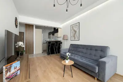 a living room with a couch and a table at Klimatyzowany Apartament z Balkonem i Przestrzenią do Pracy Lokalizacja Blisko Wisły by Noclegi Renters in Kraków