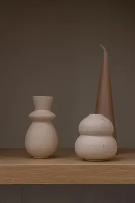 three white vases sitting on a wooden shelf at Kazimierz- Augustiańska 1- Studio with AC in Kraków