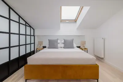 a bedroom with a large bed and a window at Apartment with mezzanine - Augustiańska 1 in Kraków