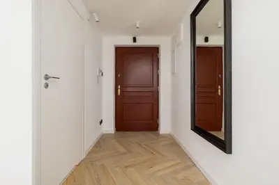a hallway with a door and a mirror at Apartment with mezzanine - Augustiańska 1 in Kraków