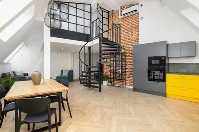 a dining room with a table and a brick wall at Apartment with mezzanine - Augustiańska 1 in Kraków