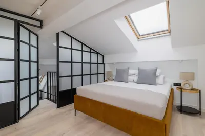 a bedroom with a large bed and windows at Apartment with mezzanine - Augustiańska 1 in Kraków