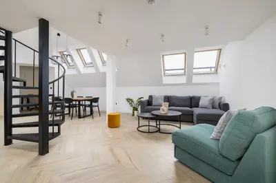 a living room with a couch and a table at Apartment with mezzanine - Augustiańska 1 in Kraków
