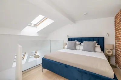a bedroom with a bed with a blue headboard at Apartment with AC- Augustiańska 1 in Kraków
