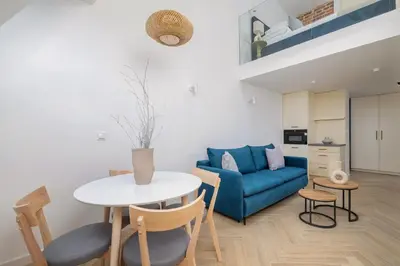 a living room with a blue couch and a table at Apartment with AC- Augustiańska 1 in Kraków