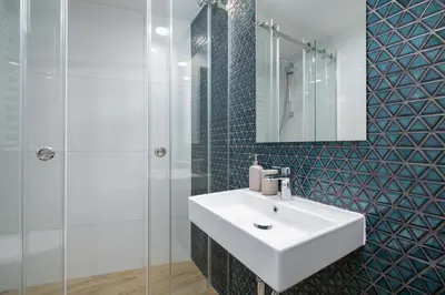 a bathroom with a white sink and a glass shower at Apartment with AC- Augustiańska 1 in Kraków