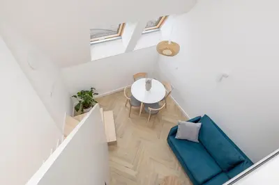 a white room with a table and a blue couch at Apartment with AC- Augustiańska 1 in Kraków