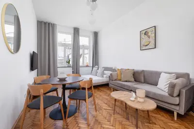 a living room with a couch and a table and chairs at 2 Bedroom apartment with AC - Augustiańska 1 in Kraków
