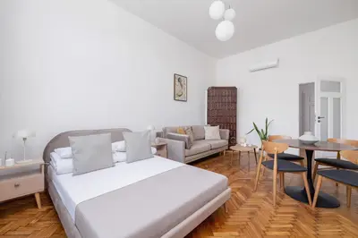 a bedroom with a bed and a couch and a table at 2 Bedroom apartment with AC - Augustiańska 1 in Kraków