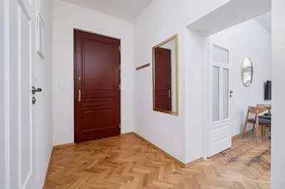 a hallway with a wooden door and a mirror at 2 Bedroom apartment with AC - Augustiańska 1 in Kraków