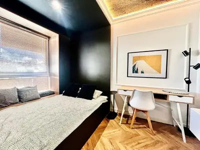 a bedroom with a bed and a desk at Urban Chic Panorama - Design Apartaments in Kraków