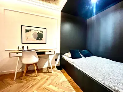 a bedroom with a bed and a desk and a chair at Urban Chic Panorama - Design Apartaments in Kraków