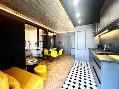 a kitchen and living room with a yellow couch and yellow chairs at Urban Chic Panorama - Design Apartaments in Kraków