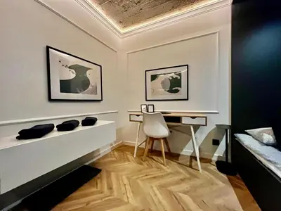 a room with a desk and a bed and a chair at Urban Chic Panorama - Design Apartaments in Kraków