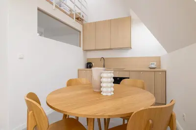 a kitchen and dining room with a wooden table and chairs at Modern Loft apartment -Kazimierz district in Kraków