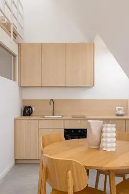 a kitchen with a wooden table and chairs at Modern Loft apartment -Kazimierz district in Kraków