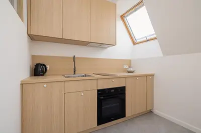 a kitchen with wooden cabinets and a sink and a window at Modern Loft apartment -Kazimierz district in Kraków