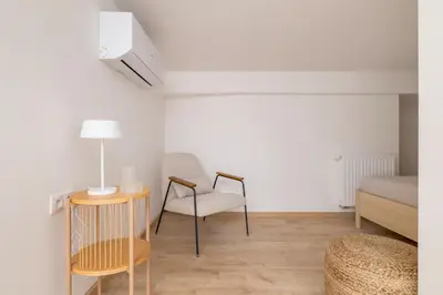a room with a bed and a chair and a table at Modern Loft apartment -Kazimierz district in Kraków