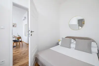 a white bedroom with a bed and a mirror at Kazimierz Area - Augustiańska 1 street in Kraków