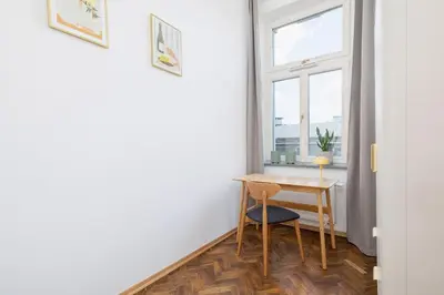 a small table and chair in a room with a window at Kazimierz Area - Augustiańska 1 street in Kraków