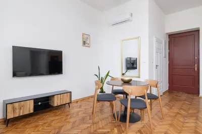 a living room with a table and chairs and a tv at Kazimierz Area - Augustiańska 1 street in Kraków